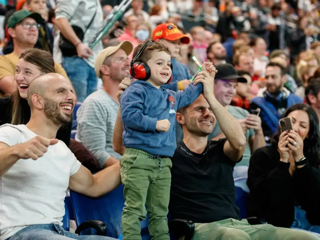 Families and motorsport fans watching monster trucks and demolition derby events.