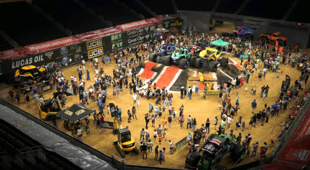 A large crowd of people standing around a monster truck