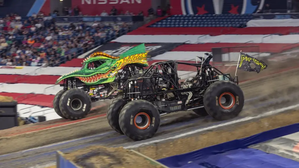 Side-by-side monster truck racing action during Philadelphia bracket competition.