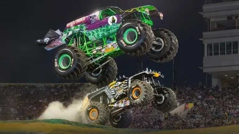 Monster trucks competing on dirt track inside Lincoln Financial Field in Philadelphia.