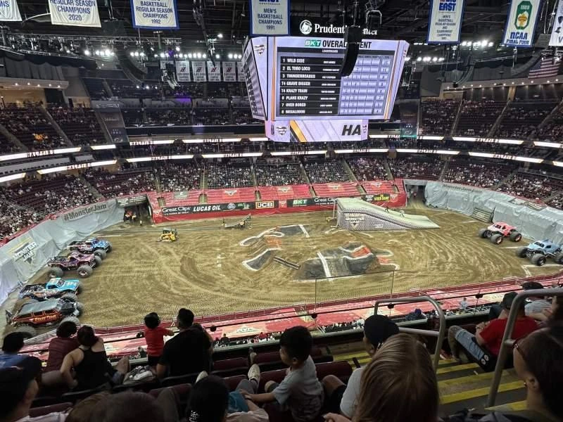 Grandstand seating overlooking dirt track during monster truck and derby events.